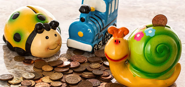 3 child piggy banks stacked on a bunch of change.